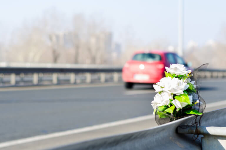 white flowers on the side of a highway marking the location where a person has died