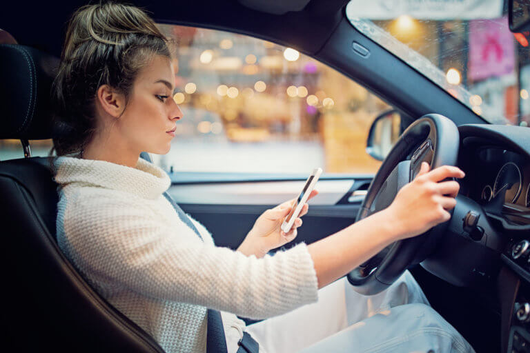 Woman on her phone in her car.