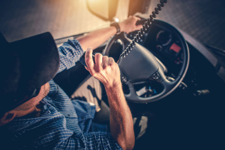 man in hat driving a truck