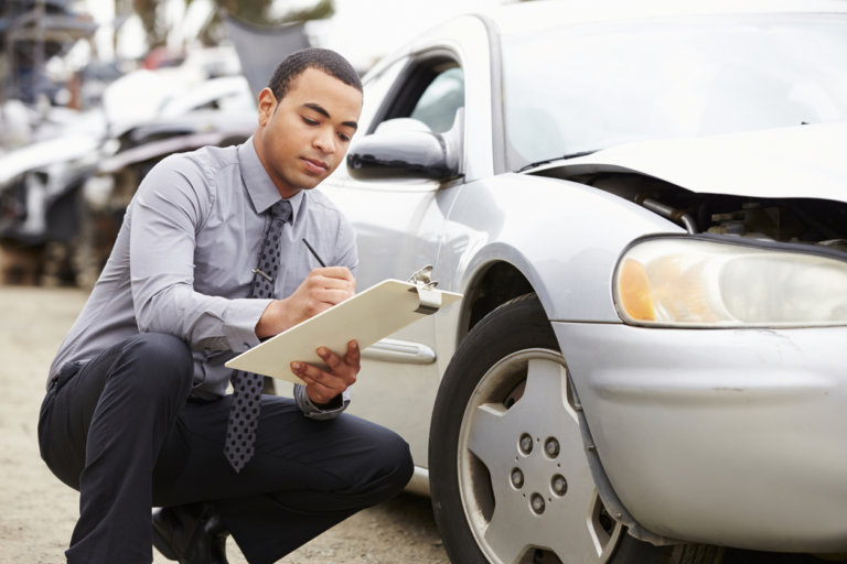 insurance adjuster recording car damage