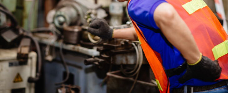 Industrial worker clutching back in pain