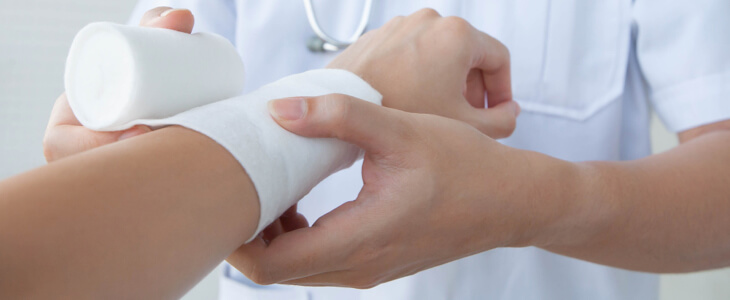 Doctor wrapping a patient's arm after a burn injury