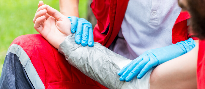 Medical worker treating burns on man's hand, catastrophic injuries