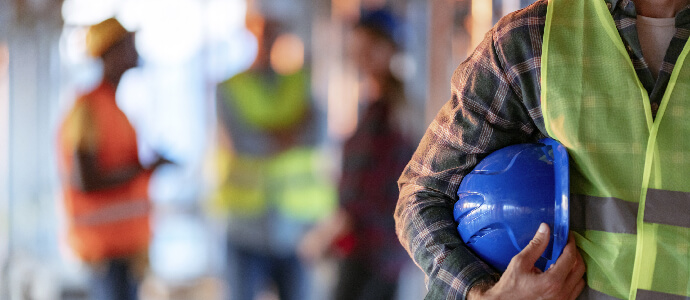 Construction worker holding helmet