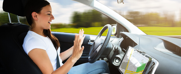 woman driving a car with no hands on the steering wheel