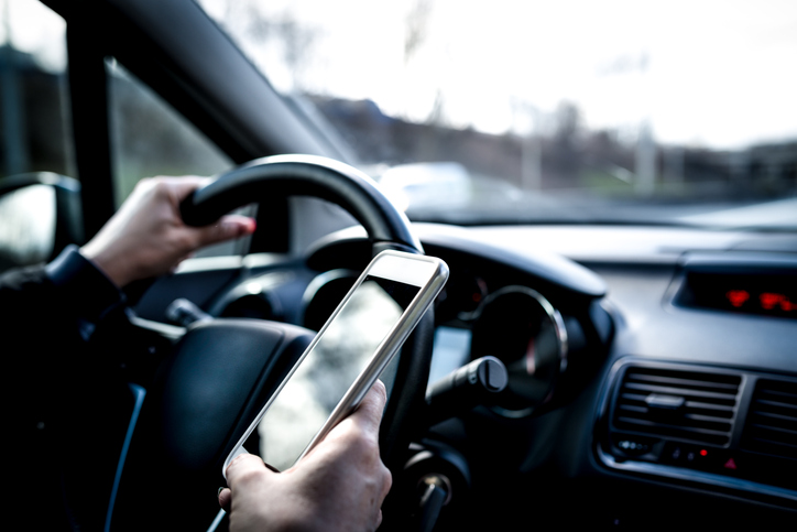 man on cell phone behind the wheel