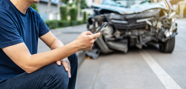 man calling attorney at car accident scene