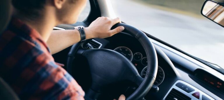 driver turning a steering wheel in a car