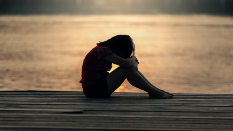 Woman crying near water