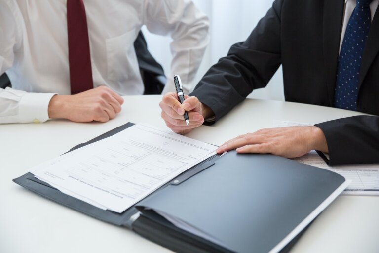 Hands writing on top of lawsuit document for a car accident