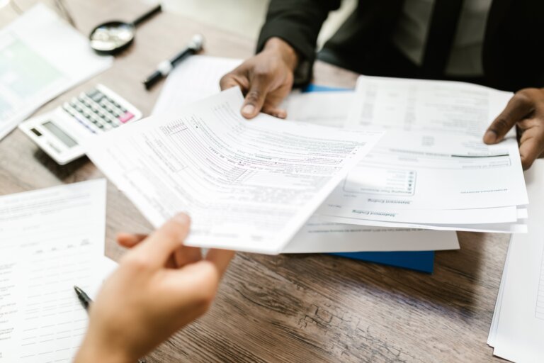 Two hands exchanging an insurance document.