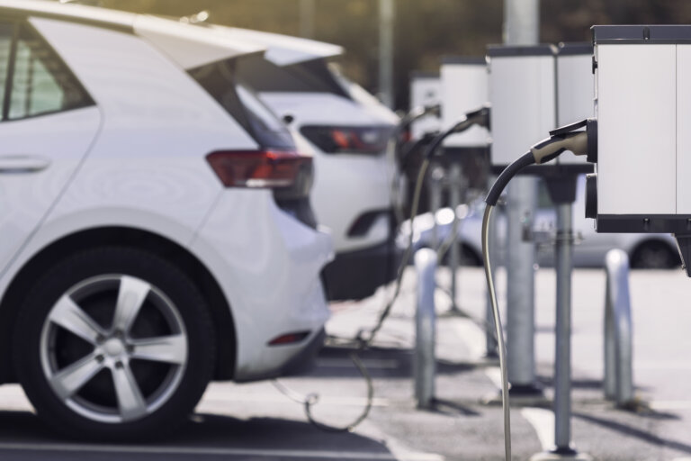 line of tesla vehicles at charging stations