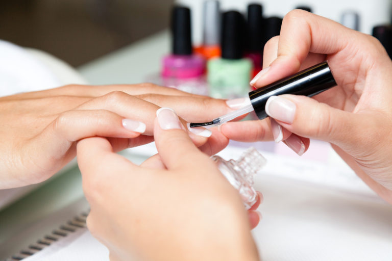nail polish being applied to a lady's finger nails