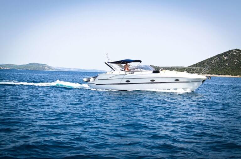 white boat cruising on deep blue water