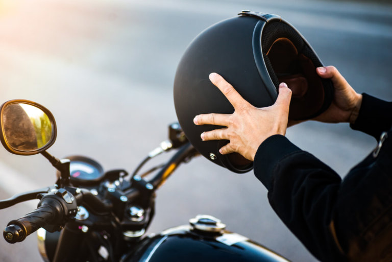 person holding black helmet on a motorcylce