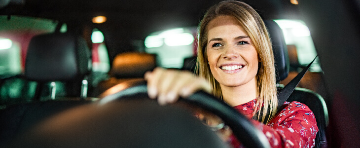 blonde woman smiling and driving uninsured motorist accident