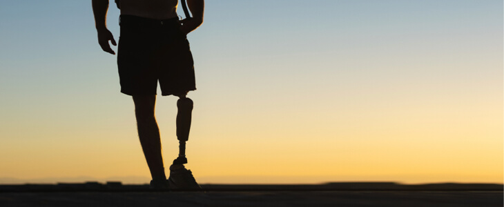 Leg amputee with prosthetic watching the sunset