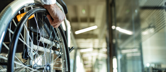 Businessman Sitting On Wheelchair In Office during the day, paraplegia injury
