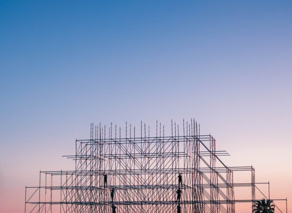 Construction accident lawyer - construction workers on scaffolding during sunset