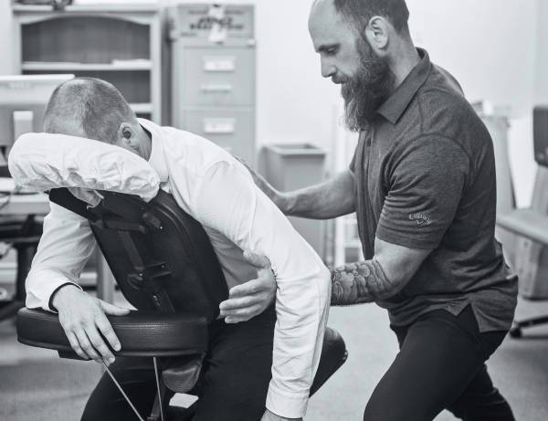 chiropractor adjusting a patients back in a chair after a car accident