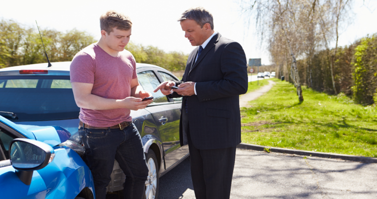 Men exchanging information after a car accident.