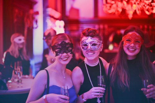Junge Frauen tragen Masken auf einer eleganten Party