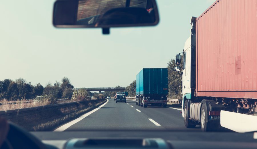 trucks driving on a highway seen from inside of a car