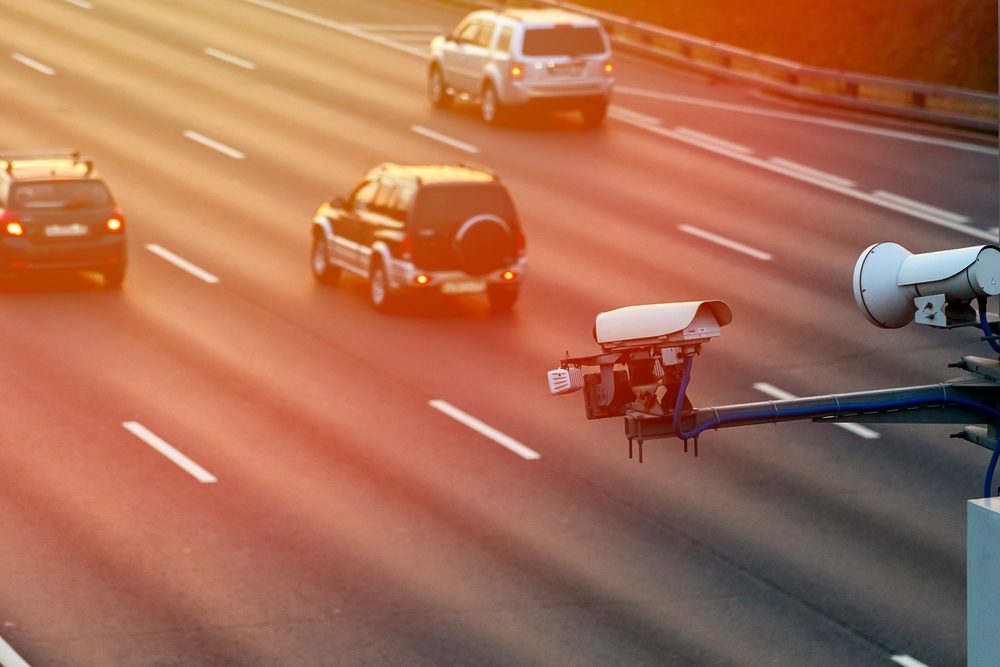 The photo depicts a traffic camera over a busy intersection. A San Jose car accident lawyer can help you learn how to get traffic & red-light camera footage in San Jose.